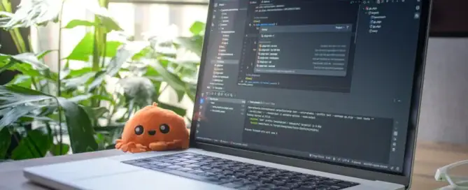 Laptop displaying software development code on a desk