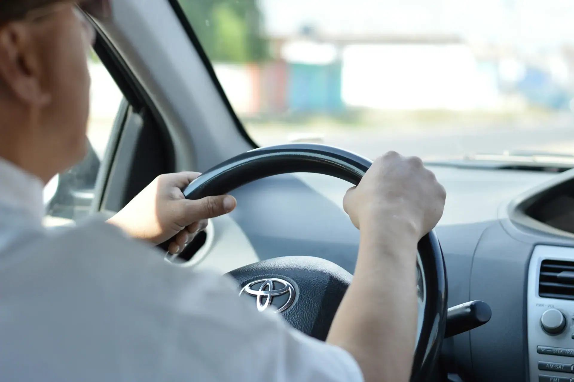 Driver behind the wheel of a car representing companion transport services.